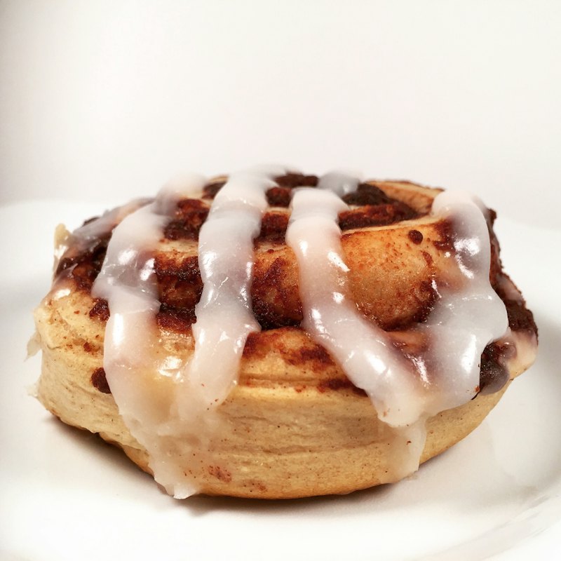 A cinnamon roll drizzled with white icing